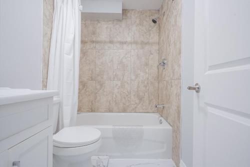 a white bathroom with a toilet and a shower at Bright Modern 1BR Suite Free Parking Fast WiFi Self Check-In in Bowmanville