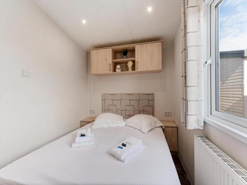 a small bedroom with a bed and a window at Comfortable mobile home in Middelkerke in Middelkerke
