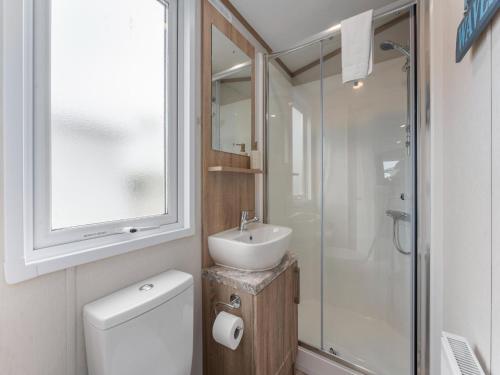 a bathroom with a toilet and a sink and a shower at Chalet in De Haan with terrace in De Haan