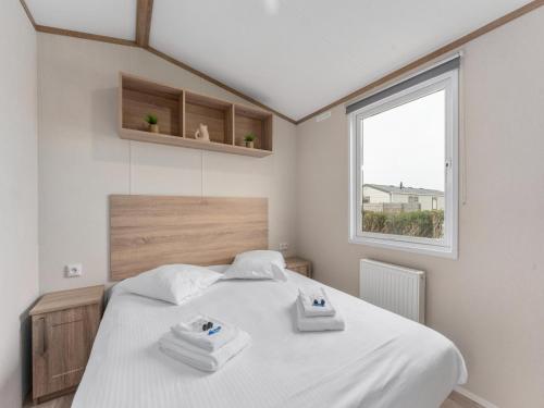a bedroom with a bed with two towels on it at Chalet in De Haan with terrace in De Haan