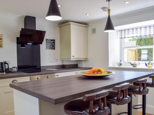 a kitchen with a bowl of fruit on a counter at Tyn Y Coed in Bettws-Evan