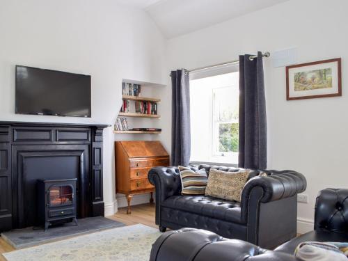 a living room with a couch and a fireplace at Tyn Y Coed in Bettws-Evan