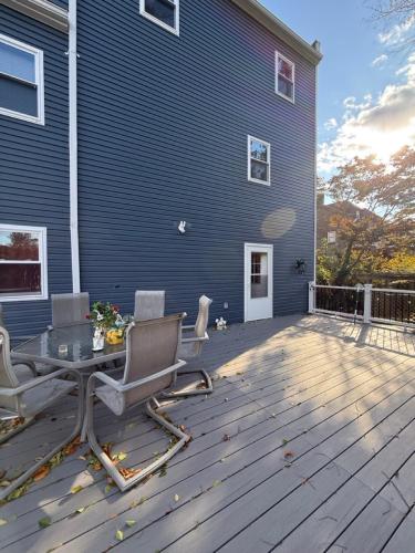 a wooden deck with a table and chairs on a house at Spacious private room in a new house with private bathroom close to center city in Philadelphia