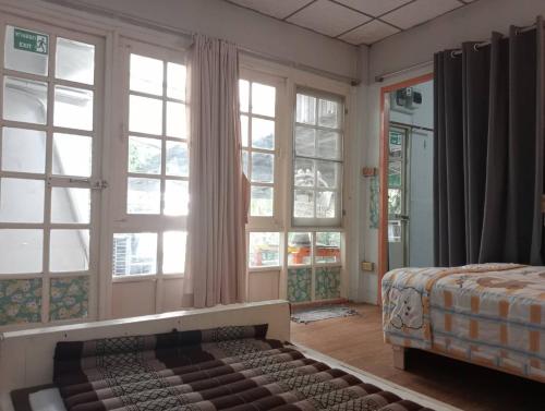 a bedroom with large windows and a bed in it at Social Style Culture in Bangkok