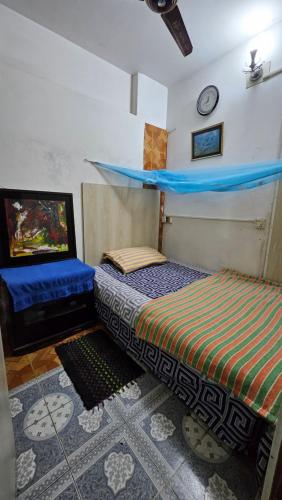 a bedroom with two beds and a tv in it at Kompass Sky Garden Home in Dhaka