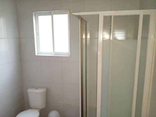 a bathroom with a toilet and a window at Cabañas Uenke in Puerto Puyuhuapi