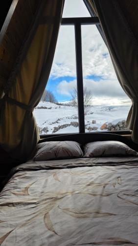 a bed in a tent with a view of a snow covered field at Cottage MATEJ in Podgorica