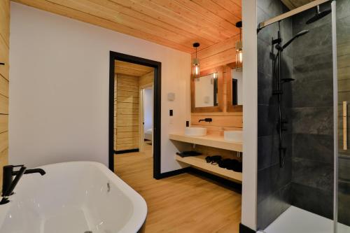 a bathroom with a white tub and a sink at Aspen - 5 chambres - 18 personnes in Saint-Férréol-les-Neiges