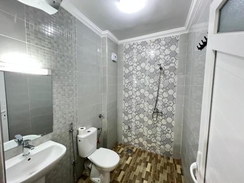 a bathroom with a white toilet and a sink at Residence Almahaj in Laayoune