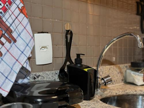 a toaster sitting on a kitchen counter next to a sink at Flat com Ar, Piscina, Garagem, Cozinha e Wi-Fi in Campo Grande