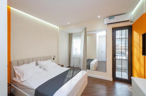 a bedroom with a large white bed and a mirror at Mashtots Avenue 31 in Yerevan