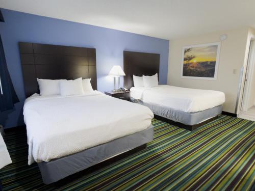 a hotel room with two beds and two lamps at Beacon Inn & Suites in Lincoln