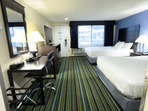 a hotel room with two beds and a desk at Beacon Inn & Suites in Lincoln