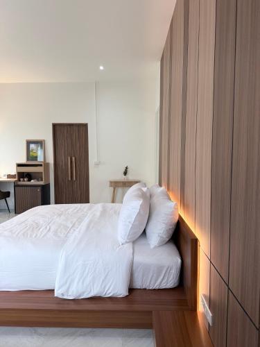 a bedroom with a bed with white sheets and pillows at Booze room in Ban Khlong Chi Lat