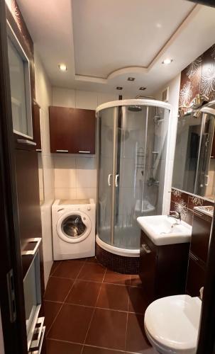 a bathroom with a shower and a washing machine at Fokus-pokus in Piotrków Trybunalski