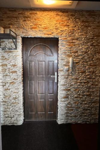 a wooden door in a brick building with a stone wall at Fokus-pokus in Piotrków Trybunalski