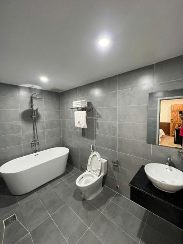 a bathroom with a tub and a toilet and a sink at Hùng Thi Hotel in Cái Răng