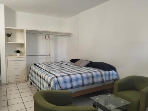 a bedroom with a bed and two chairs at Sierra 5 in Acapulco