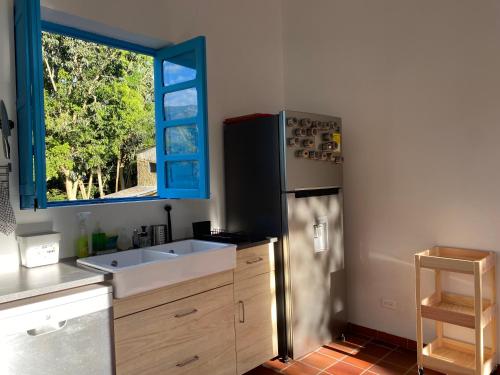 a kitchen with a refrigerator and a sink and a window at Quinta Sans-Soucis in Choachí