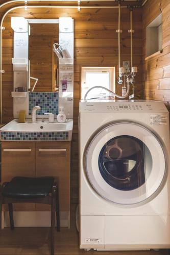 a washing machine in a kitchen with a sink at コテージコッタロ in Gojikkoku
