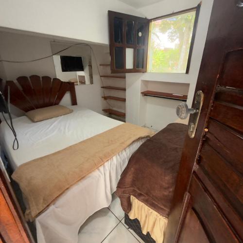 a small bedroom with a bed and a window at Vila morro casas de praia in Cairu