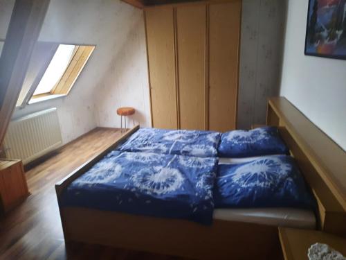 a bedroom with a bed with blue sheets and a window at Ferienwohnung Brockenblick in Halberstadt