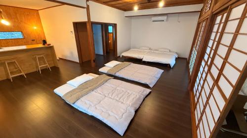 a room with three beds in it with a kitchen at ふなだけの家 in Shinano