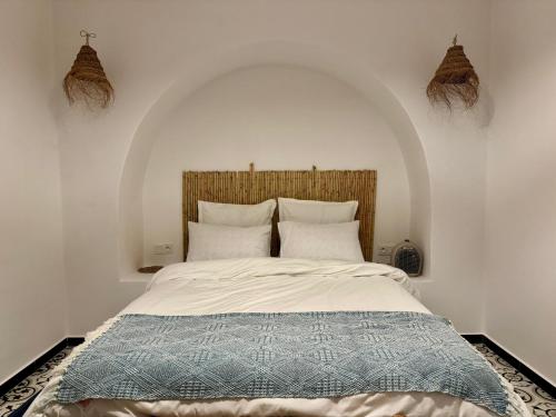 a bedroom with a large bed with an arched headboard at Casa Norte in Tétouan