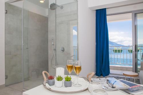 a bathroom with a shower and two glasses of wine at Boutique Hotel and Spa Blanc & Bleu - Blanche in Herceg-Novi