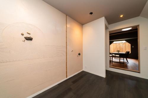 a hallway with white walls and a dining room with a table at 三十三Kumo in Kyoto