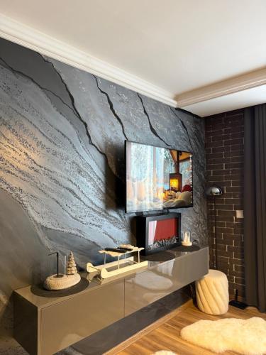 a living room with a tv on a wall at Black Elegant & Spa Kop in Kopaonik
