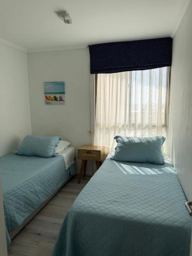 a bedroom with two beds and a window at Departamento frente a la playa in Arica