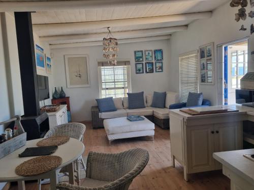 a living room with a couch and a table and chairs at Pondok in Paternoster