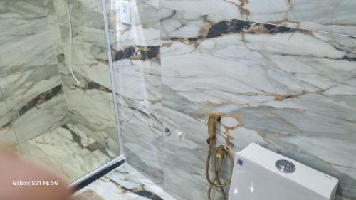 a bathroom with a shower with a marble wall at Barrinha Beach flats in Saquarema