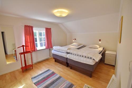 a bedroom with a large bed and red curtains at Ribbingshof Herrgård - Flygeln in Norra Vi