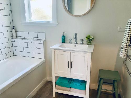 a bathroom with a sink and a bath tub and a sink at Country Bliss Cottage in Greytown