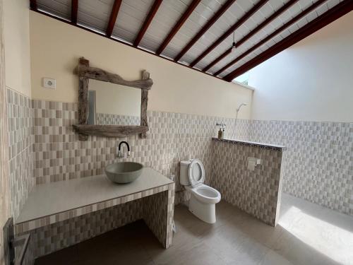 a bathroom with a sink and a toilet at Ganesha Amed in Amed