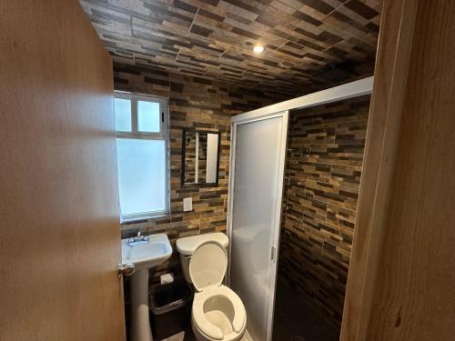 a bathroom with a toilet and a sink at La Escondida Cabañas in Mineral del Monte