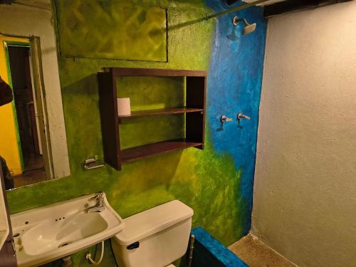 a green bathroom with a sink and a toilet at Habitación cama doble con vista al bosque - 4 cuadras parque de Usaquen in Bogotá