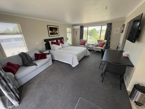 a living room with a bed and a couch at Cambridge Te Awa Rivertrail BnB in Cambridge