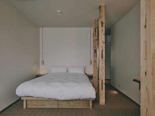 a bedroom with a bed with a wooden frame at mont - Nozawa Onsen Ski Resort in Nozawa Onsen