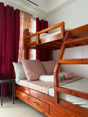 a bedroom with two bunk beds and a couch at RD Bliss Staycation - SMDC Condo Tower B in Kaybagal