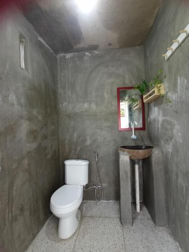 a bathroom with a toilet and a sink at JE House in Ambarita
