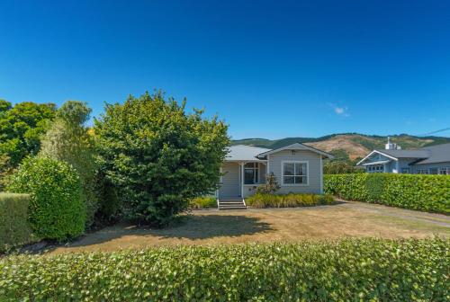 a house with a yard with bushes at Corokia Villa - Peaceful, Modern Villa in Richmond in Richmond