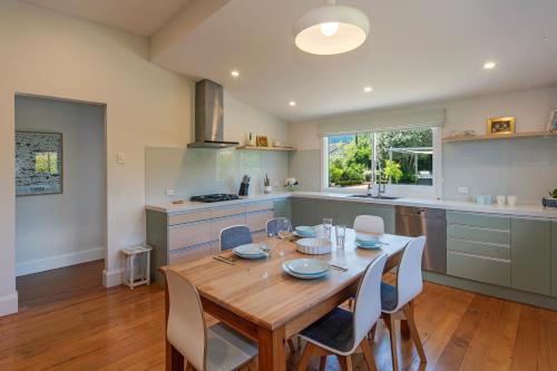 a kitchen and dining room with a wooden table and chairs at Corokia Villa - Peaceful, Modern Villa in Richmond in Richmond