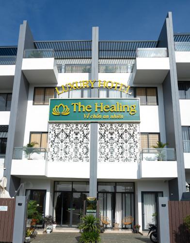 a building with a sign that reads the healing at The Healing Luxury Hotel in Buon Ma Thuot