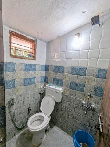 a small bathroom with a toilet and a window at Sri Krishna 4BHK AC Villa in Udupi