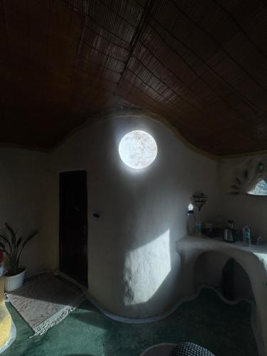 a room with a round window on the wall at The Cob House in Chauntrā