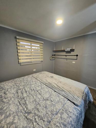 a bedroom with a bed and a window at Refugio Titi3 in Coronel
