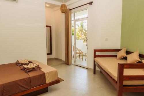 a bedroom with two beds and a door to a patio at Lost Paradise Sri Lanka in Mirissa
